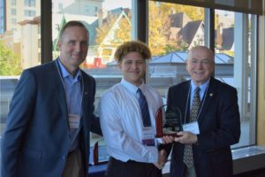 Malcom Clark receives his award from President Ray Cross