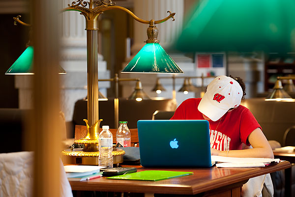 Picture of a student using a laptop at a desk in the Wisconsin Historical Society library reading room.