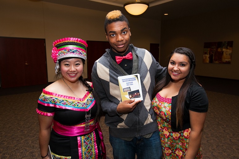 multicultural performance group including a woman in traditional Hmong dress, African American man and another non White woman