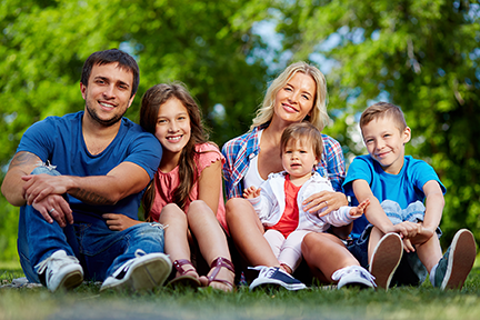 Photo of happy family looking at camera. Photo includes mom, dad, and three children.