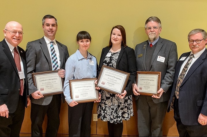 Regent Scholar Award recipients Dr. Christopher Hartleb (second from left), Dr. Heather Schenck (center left), Dr. Jennifer Dahl (center right), and Dr. Tim Lyden (second from right) are pictured with UW System President Ray Cross (left) and UW System Regent Emeritus Mark Tyler (right) during a University of Wisconsin Board of Regents meeting held in Varsity Hall at the University of Wisconsin-Madison on Feb. 5, 2015. Not pictured: Dr. Junhong Chen (Photo by Bryce Richter / UW-Madison)
