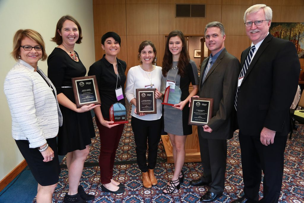 (from left) Julie Bauer, Kristin Plessel, Nicole Maala, Jennifer Smilowitz, Catherine Finedore, M. Keith Thompson, and Jim Henderson, UW System Vice President for Academic and Student Affairs. Not pictured: Janerra Allen and Angela Yang. (Photo credit: Joe Koshollek)