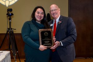 Bee Vang holds award with group