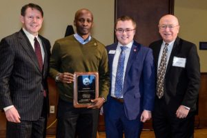 Kimamo Wahome holding award