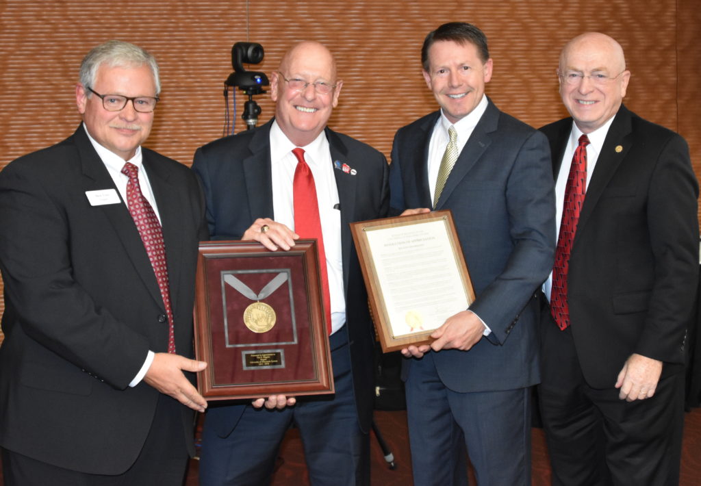 Photo of Regent Emeritus Higgins (second from left) accepting a resolution of appreciation for his service on the Board of Regents; also pictured (from left): Regent Tyler, Regent President Behliong, and UW System President Cross