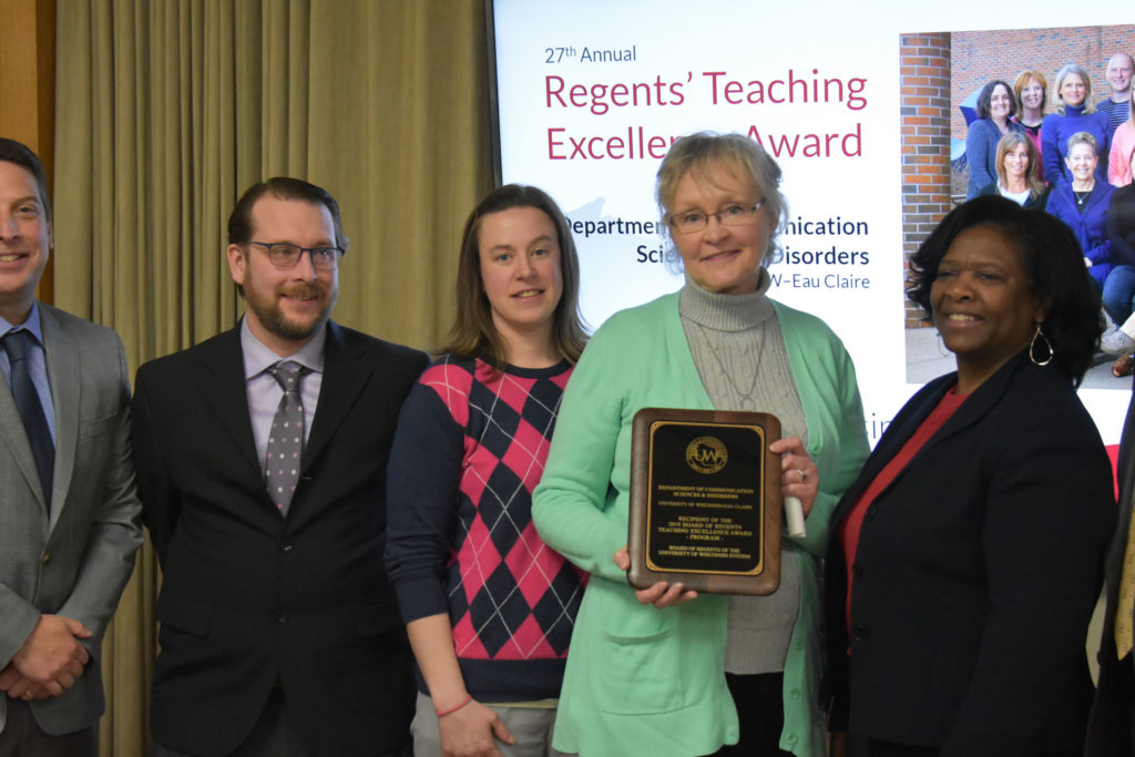 Photo of The UW-Eau Claire Department of Communication Sciences and Disorders receiving a UW System Board of Regents 2019 Teaching Excellence Award at the Board of Regents meeting held in Madison on April 5, 2019. Pictured from left: Assistant Professor Thomas Kovacs, Associate Professor Abby Hemmerich, Department Chair Vicki Samelson, and State Superintendent of Public Instruction and Regent Carolyn Stanford Taylor, who presented the award.