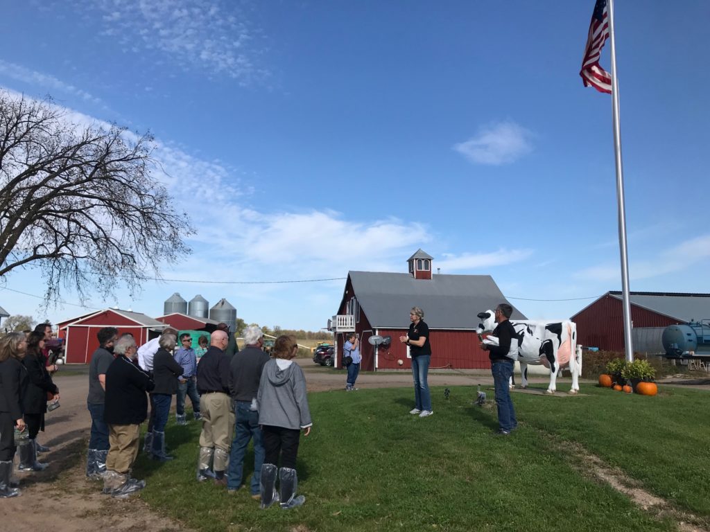 Photo of Regent Cris Peterson welcoming University of Wisconsin System officials, UW Regents, guests, and the media to a tour of her family dairy farm, Four Cubs Farm.