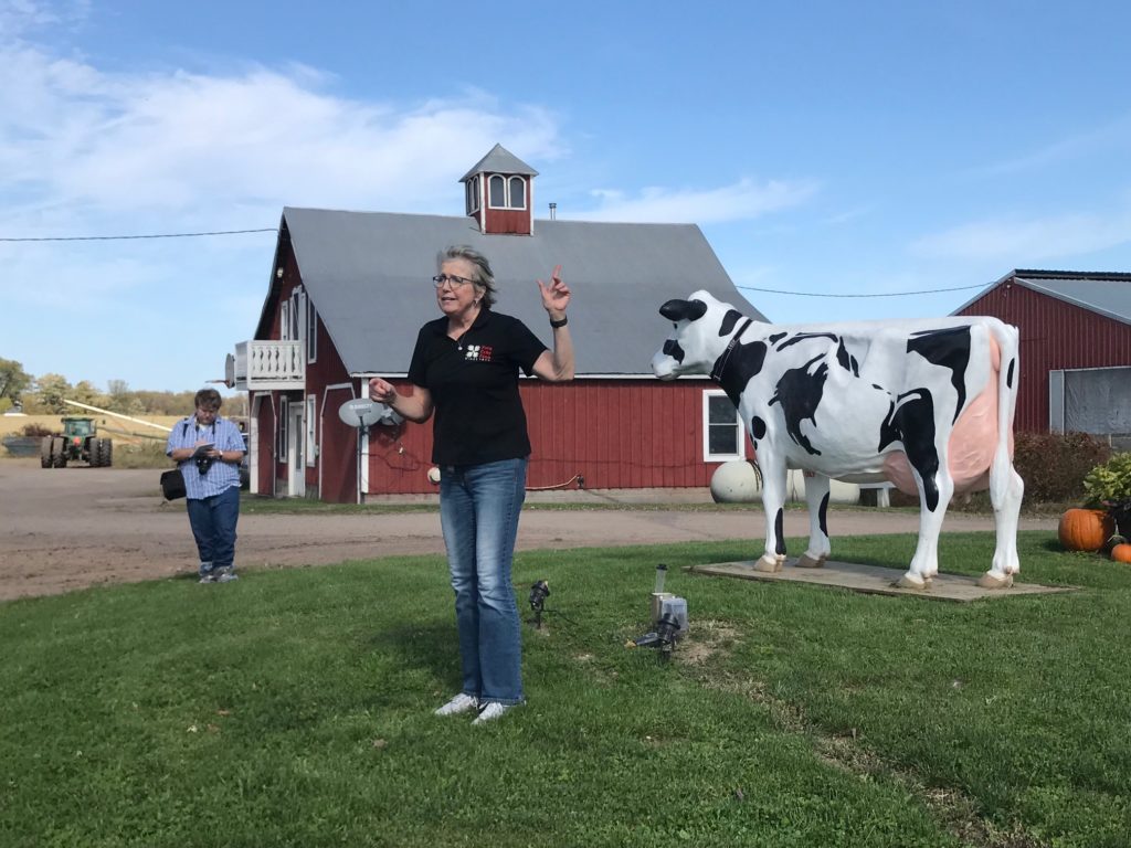 Photo of Regent Cris Peterson welcoming University of Wisconsin System officials, UW Regents, guests, and the media to a tour of her family dairy farm in Grantsburg, Wis.