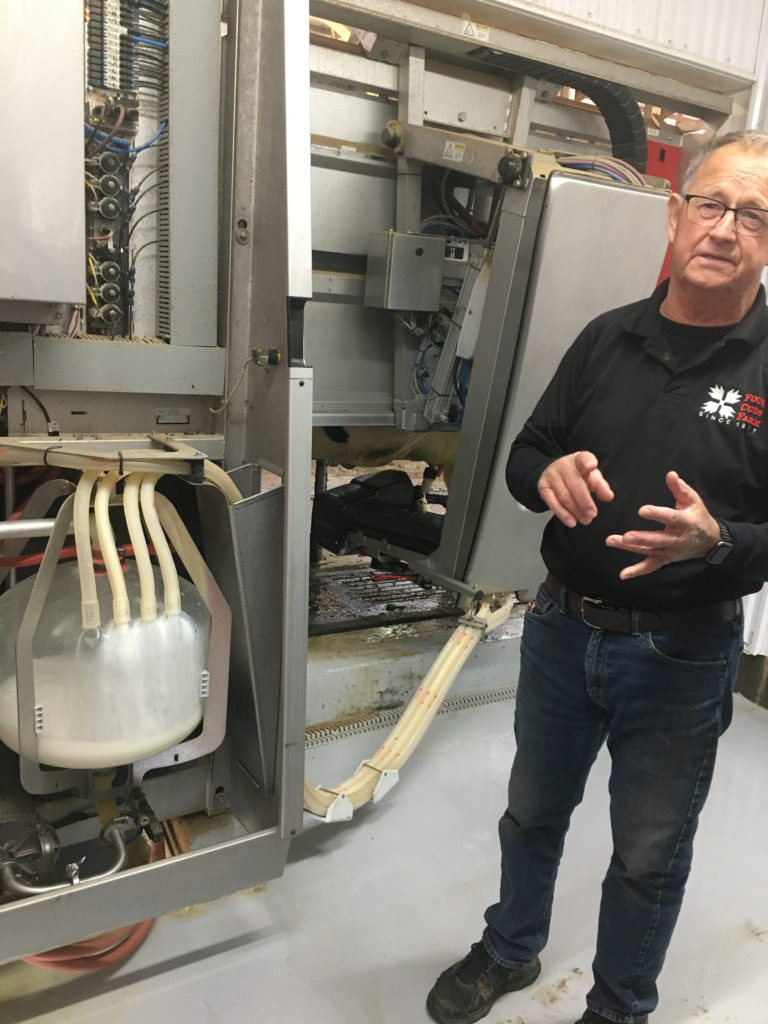 Photo of Gary Peterson, CEO of Four Cubs Farm, describes the automated milking operation at Four Cubs Farm.