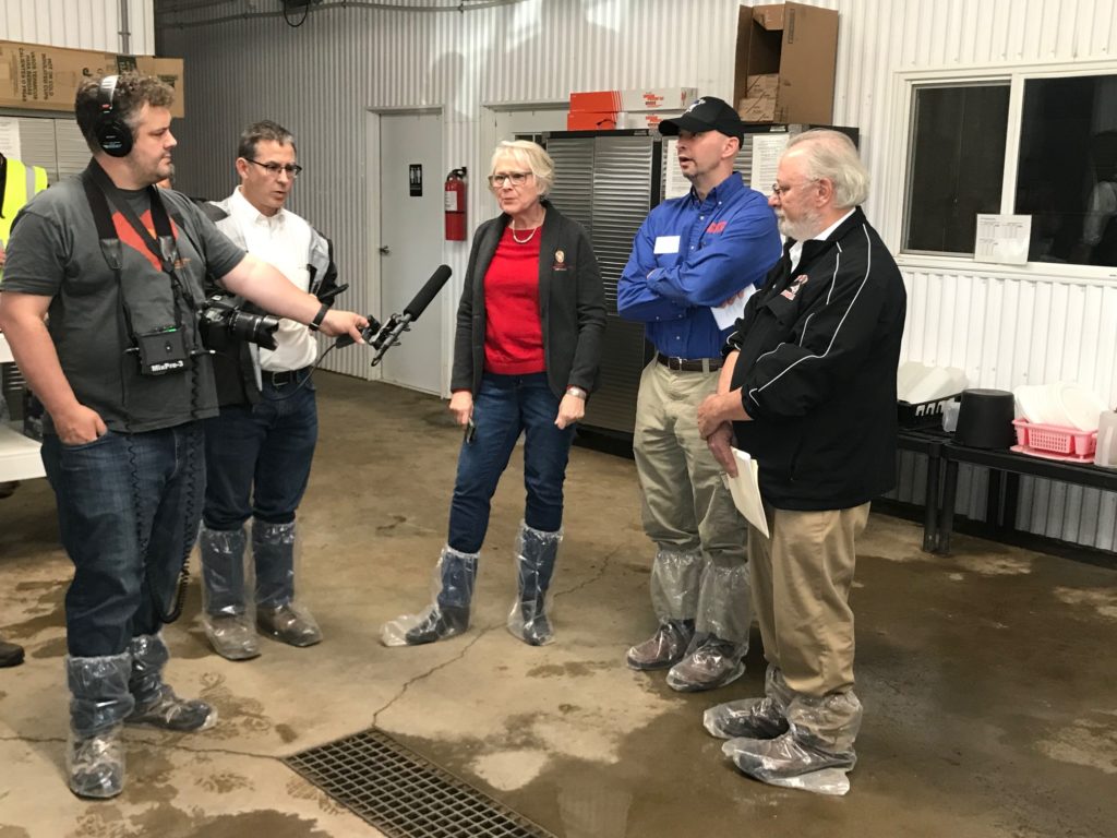 Photo of Kate VandenBosch, Dean of the College of Agricultural and Life Sciences at UW-Madison (left), Wayne Weber, Dean of the College of Business, Industry, Life Science and Agriculture at UW-Platteville (middle), and Dale Gallenberg, Dean of the College of Agriculture, Food and Environmental Sciences at UW-River Falls (right), discussing the impact of the $8.8 million Dairy Innovation Hub at a news conference at Four Cubs Farm in Grantsburg.