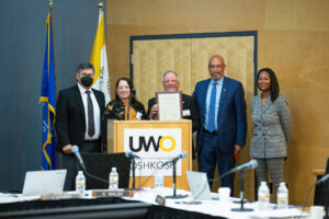 Photo of Gary Karner, center, and from left, Regent President Manydeeds, Regent Vice President Walsh, UW-Platteville Chancellor Shields, and WIAC Commissioner Harris