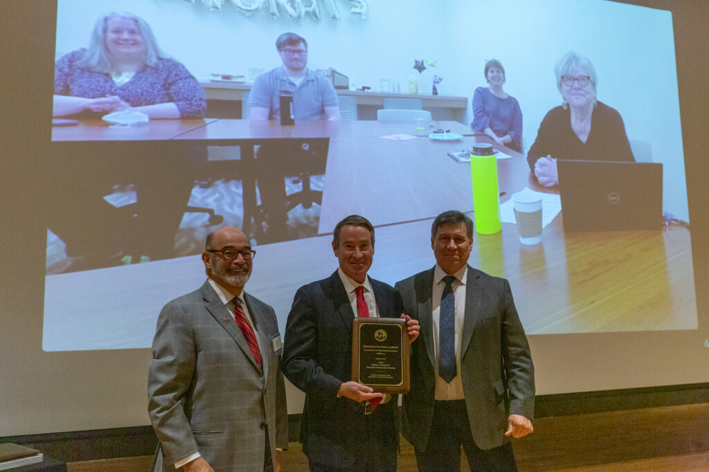 Prof. Larson (far right on screen) with (from left) UW System Interim President Michael J. Falbo, Regent Mike Jones, and Regent President Edmund Manydeeds III