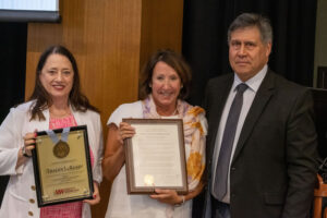 Photo of Regent Tracey Klein (center) receiving her resolution of appreciation with Regent President Karen Walsh (left) and Regent Edmund Manydeeds