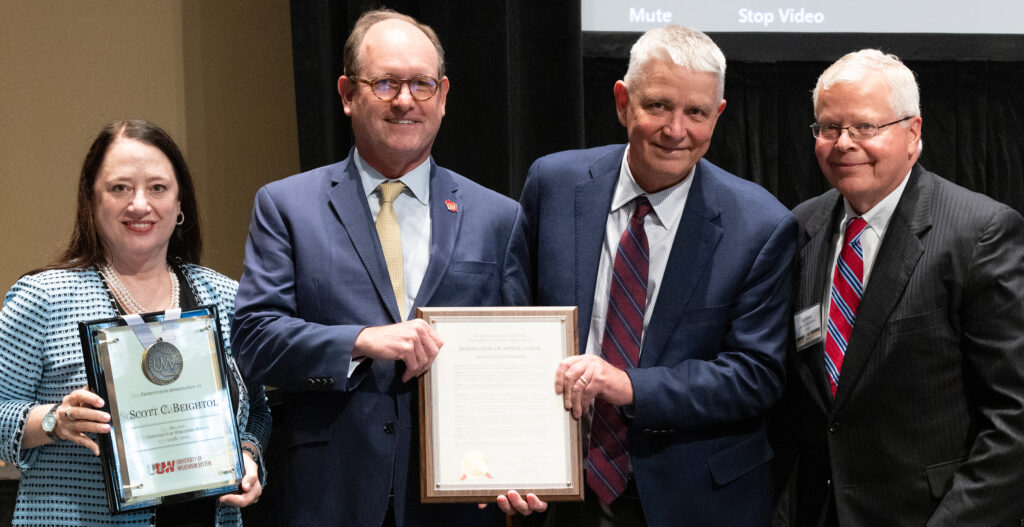 Photo of Regent Scott Beightol (second from left) accepting his resolution of appreciation for serving on the Board. Also pictured: (from left) Regent President Karen Walsh, Regent Bob Atwell, and UW System President Jay Rothman. (Photo by UWM)