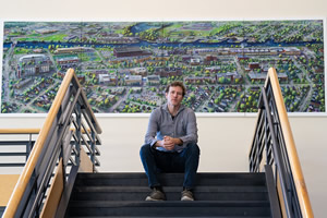 Photo of Leif Larson with his painting of UW-Oshkosh