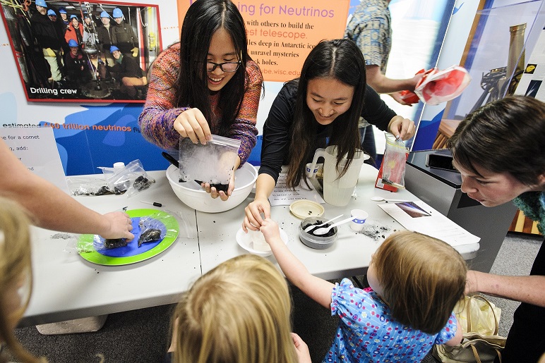 Undergraduates and UW Astronomy Club members Lin Shi, left, and Zishan Xia demonstrate how to use a mix of water, sand, ammonia, coal and dry ice to make comet material during Family Science Night at UW Space Place at the University of Wisconsin-Madison on Nov. 22, 2013. The science outreach event, presented by South Madison Promise Zone and UW Space Place, attracted more than 400 people to engage in hands-on experiments and exhibits ranging from astronomy to zoology. (Photo by Jeff Miller/UW-Madison)