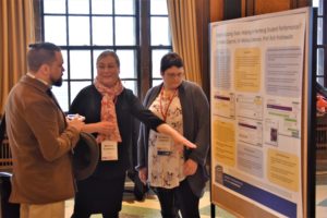 three people looking at a poster 