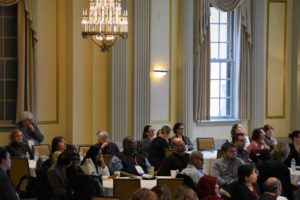 people seated at tables in the Great Hall for a plenary