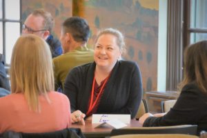 woman smiling in the middle of a group discussion