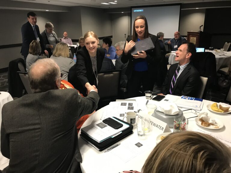 Erin Doyle Lastowka of EAB shakes hands with a UW-Whitewater leader at the February 2019 launch meeting in Madison.