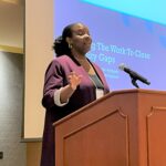 LaToya White speaking at podium for equity plenary panel at UW System Navigate and Advising Workshop March 2023 at UW-Stevens Point