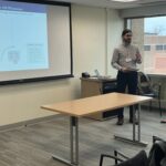 Nathan Callope, standing and gesturing at left, next to Jessica Stein, both of UW-Whitewater, at a coordinated communication and intervention breakout session at the UW System Navigate and Advising Workshop March 9, 2023, at UW-Stevens Point