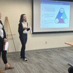 Karen Drees, standing at left, and Haley Rusk, standing and gesturing at right, both of UW-Platteville, at the front of the breakout session at the UW System Navigate and Advising Workshop March 9, 2023, at UW-Stevens Point