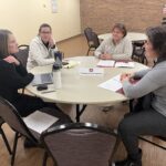 4 people seated at a round table in the Training and Development discussion session at the UW System Navigate and Advising Workshop March 9, 2023, at UW-Stevens Point