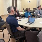 5 people seated at a round table at the UW System Navigate and Advising Workshop March 9, 2023, at UW-Stevens Point