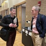 Matthew Petersen of Northeast Wisconsin Technical College and John Achter of UW System Administration standing and talking at the UW System Navigate and Advising Workshop March 9, 2023, at UW-Stevens Point