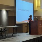 Angela Kellogg of UW System Administration standing at podium for closing session at the UW System Navigate and Advising Workshop March 9, 2023, at UW-Stevens Point