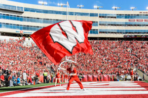 Photo of a member of the UW Spirit Squad waving a giant W flag after the Badgers score a touchdown during the UW Homecoming football games versus Maryland inside Camp Randall Stadium at the University of Wisconsin-Madison on Oct. 21, 2017. The Badgers won the game 38-13. (Photo by Bryce Richter / UW-Madison)