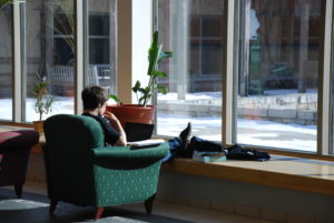 Student siting in an armchair looking out the window