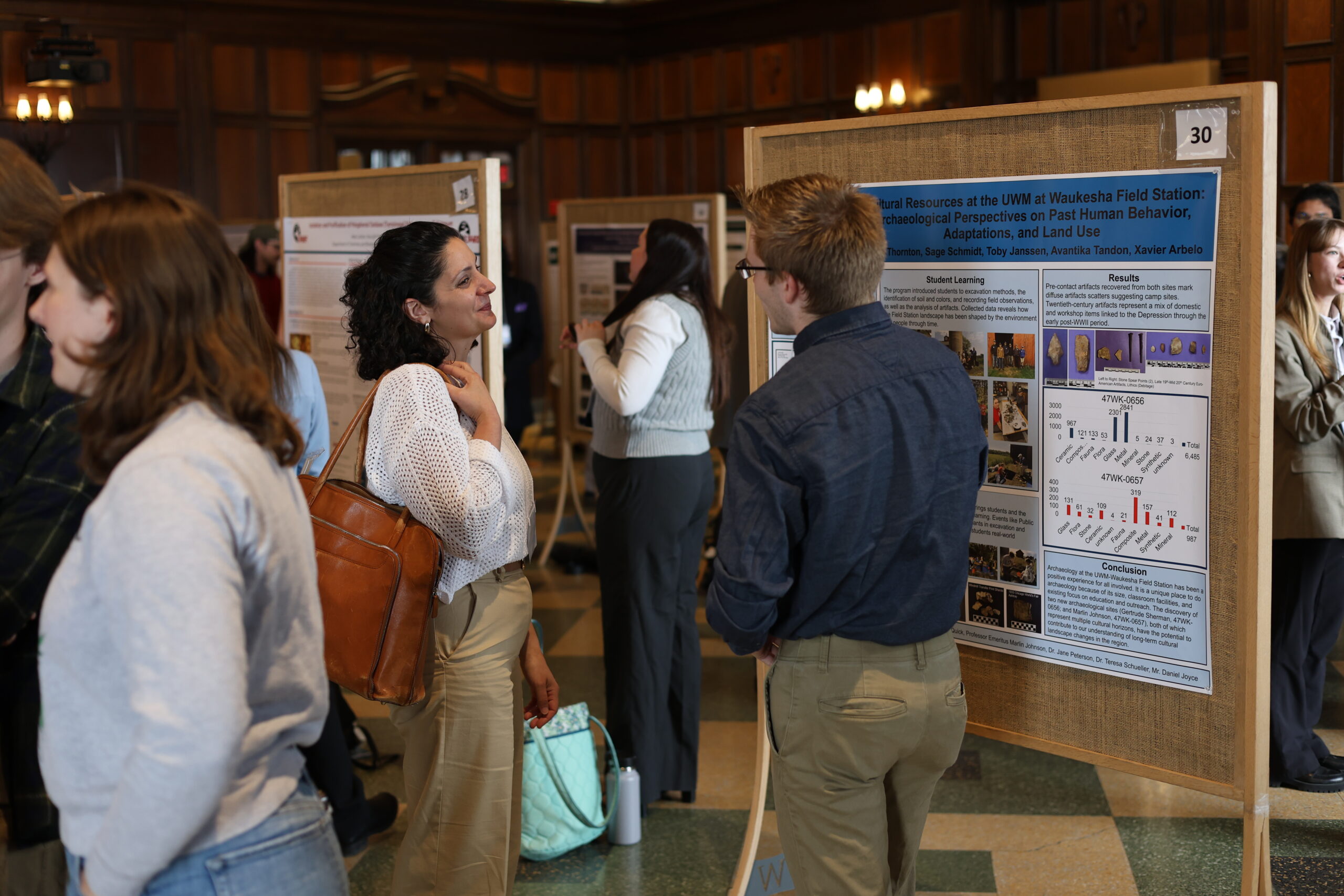 A student presenting their poster to an attendee.